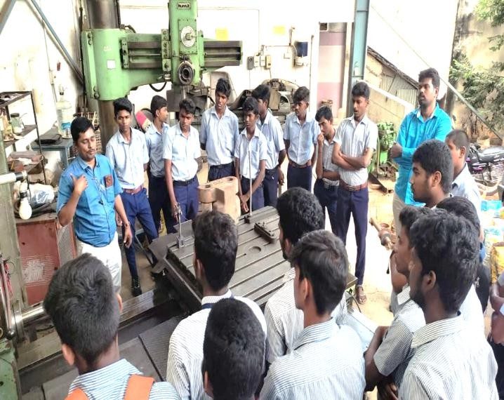 Students being briefed at the radial drilling machine during a training visit
